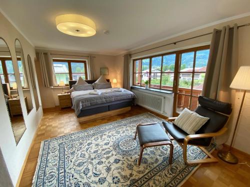 a bedroom with a bed and a chair and a rug at HAUS Alpenoase in Schönau am Königssee