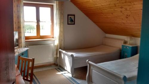 a small room with two beds and a window at Schneiderhof in Steinbach