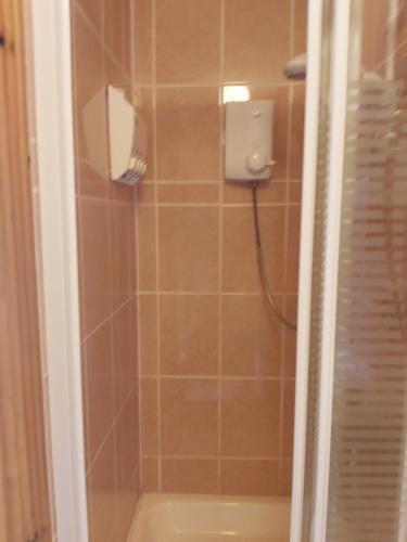 eine Dusche mit einem Seifenspender im Bad in der Unterkunft Keane's Bar & Restaurant in Blackweir Bridge