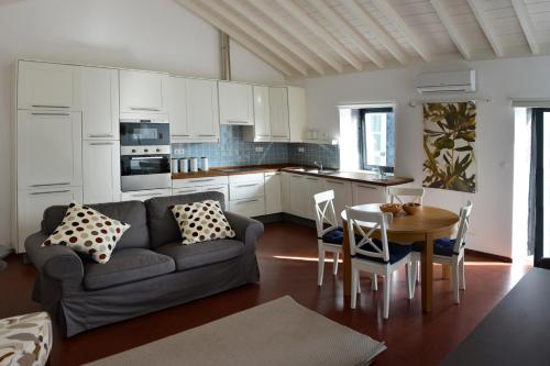 a living room with a couch and a table with chairs at Casa dos Botes - WhaleBoat House TER in São Caetano