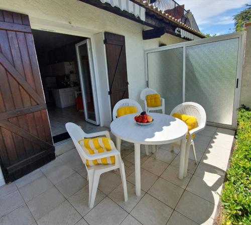 Una mesa blanca y sillas en un patio. en APPARTEMENTS DANS VILLA EN REZ DE JARDIN, en Hyères