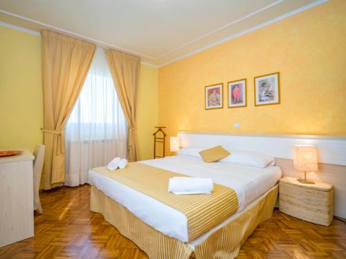 a bedroom with a large bed with yellow walls at Apartments Villa Rossella 1 in Rovinj