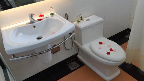 a bathroom with a white toilet and a sink at Quality Guest House in Kuantan