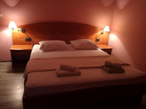 ein Schlafzimmer mit einem großen Bett mit zwei Kissen in der Unterkunft Apartmani Olivera 2 in Rab