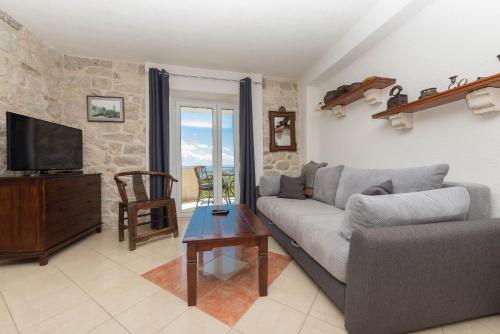 a living room with a couch and a television at Vila Divna in Podgora