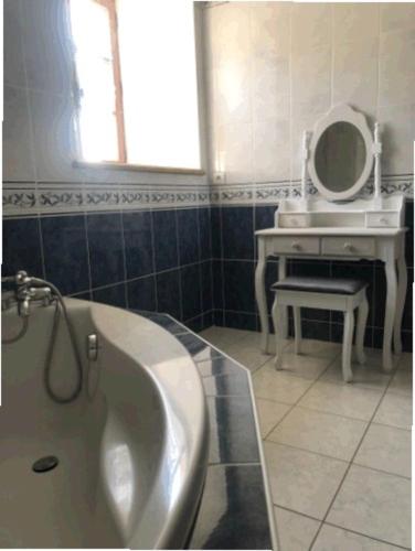 une salle de bain avec une baignoire, un lavabo et un miroir dans l'établissement Le CLOS DE L AMANDIER, à Château-Chalon