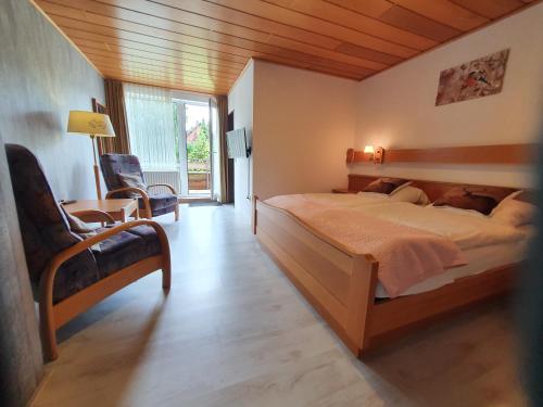 a bedroom with a large bed with a wooden ceiling at Pension Robin Hood in Willingen