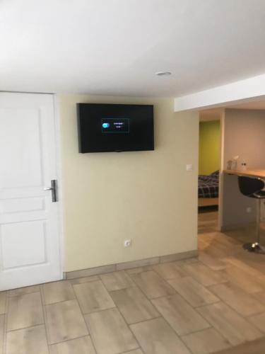 une pièce avec une télévision à écran plat sur un mur dans l'établissement Le privilège, à Champhol