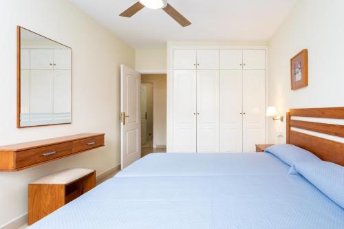 a bedroom with a blue bed and a mirror at Residencial El Llano in Valle Gran Rey