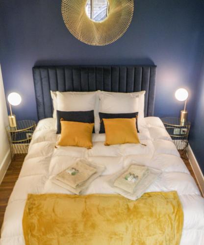 - une chambre avec un grand lit blanc et des oreillers jaunes dans l'établissement Le Petit Canut - Lyon Centre avec Terrasse - Majord'Home, à Lyon