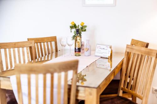 a table with a vase of flowers and wine glasses at Kärnten Apartment Turnersee in Sankt Kanzian