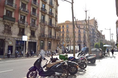 a row of motorcycles parked on a city street at BizFlats Eixample Apartments in Barcelona