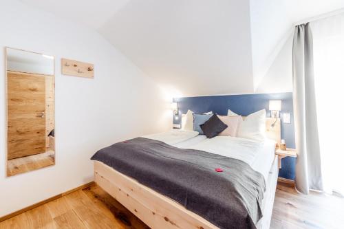 a bedroom with a large bed with a blue headboard at Kärnten Apartment Turnersee in Sankt Kanzian
