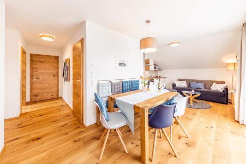 a kitchen and living room with a wooden table and chairs at Kärnten Apartment Turnersee in Sankt Kanzian