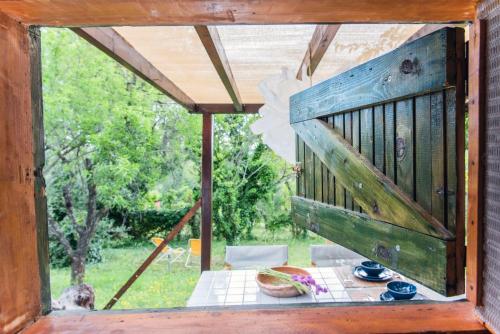 a view from the window of a porch with a table at #Pinetree Cabin by halu! Villas in Kalandra
