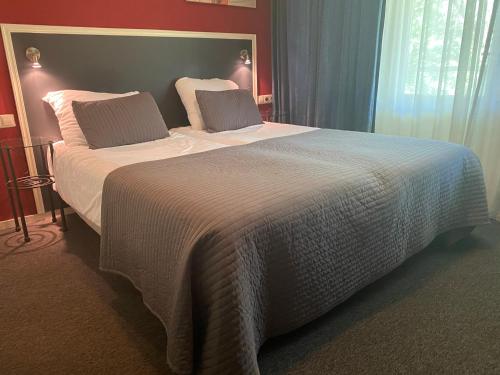 a bedroom with a large bed with white sheets and pillows at Fletcher Strandhotel Renesse in Renesse