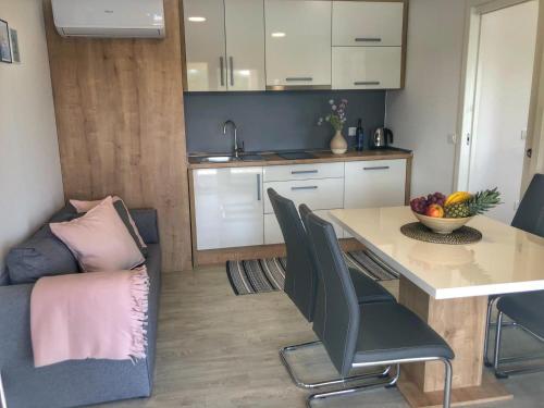 eine Küche und ein Esszimmer mit einem Tisch und einem Sofa in der Unterkunft Bella Homes Camping in Tisno
