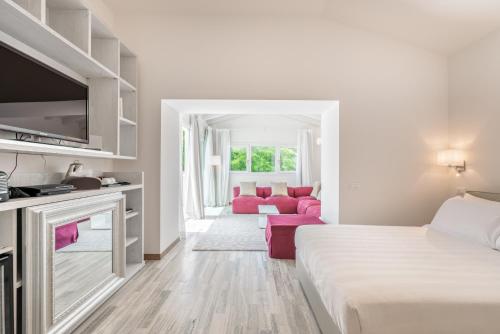 a white room with a bed and a couch at Hotel Stella Della Versilia in Marina di Massa