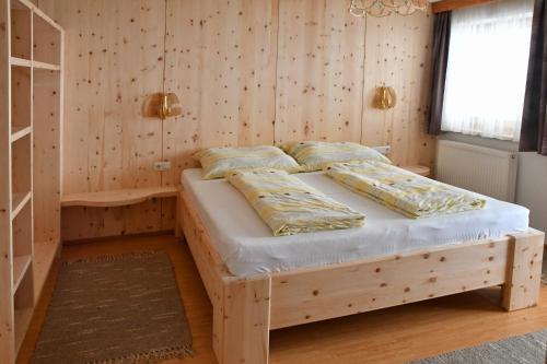 a bedroom with a bed in a wooden wall at Haus Dengg in Zellberg