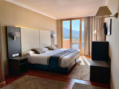 ein Schlafzimmer mit einem großen Bett und einem großen Fenster in der Unterkunft Hotel Armiñe in Basauri