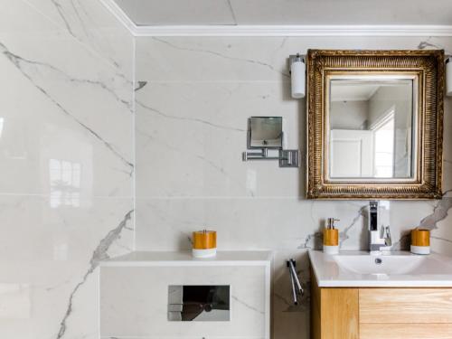 une salle de bain avec un lavabo et un miroir dans l'établissement Cannes Croisette Majestic Miramar, à Cannes