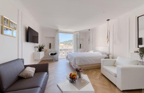 un salon avec un lit et un canapé dans l'établissement Cannes Croisette Majestic Miramar, à Cannes