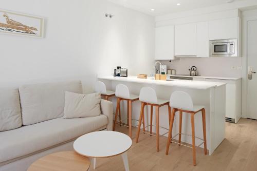 a living room with a couch and a kitchen at Hotel SANSEbay in Donostia-San Sebastián