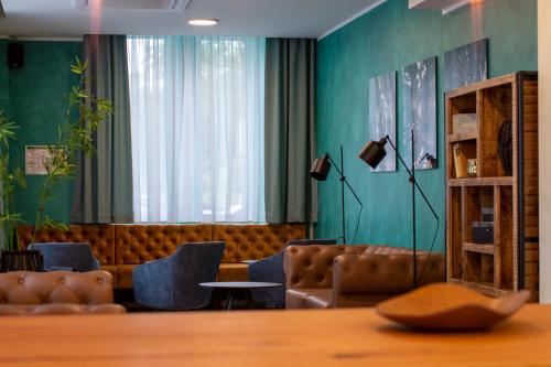 a waiting room with a couch and chairs and a table at Trip Inn Hotel & Suites Essen in Essen