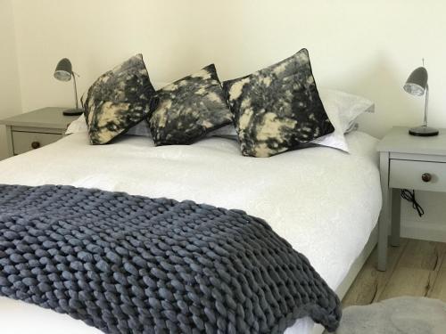 a bed with black and white blankets and pillows at Meadow view apartment in Carncastle