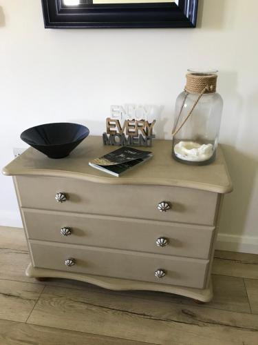 a dresser with a vase on top of it at Meadow view apartment in Carncastle