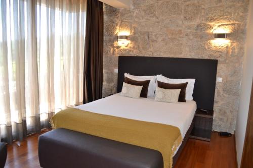 a bedroom with a large bed in a room at Quinta do Medronheiro Hotel Rural in Viseu