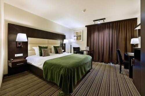 a hotel room with a bed and a desk at Hotel Charleroi Airport - Van Der Valk in Charleroi