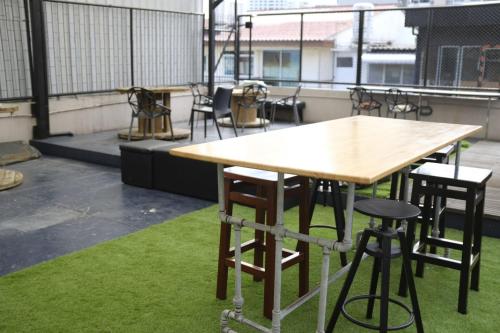 曼谷The Blocks Hostel Sukhumvit 10的一张木桌和阳台上的一些椅子