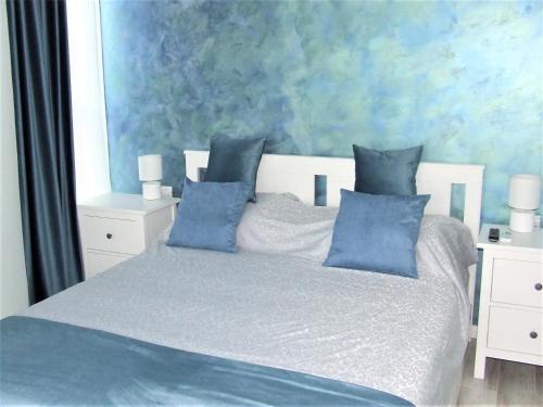 a bedroom with a bed with blue pillows at ALEXYS TOP RESIDENCE in Mamaia Sat/Năvodari