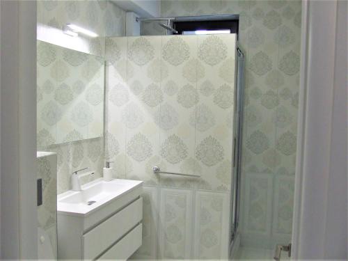 a bathroom with a shower and a sink and a mirror at ALEXYS TOP RESIDENCE in Mamaia Sat/Năvodari