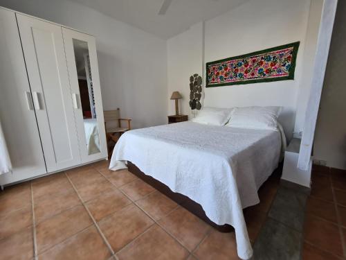 a bedroom with a white bed and a mirror at Las Negras CENTRO. Al lado del mar. Con dos terrazas in Las Negras