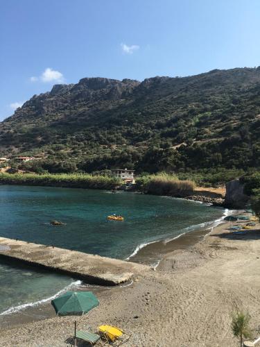 a beach with umbrellas and boats in the water at Dream House Efi in Ravdhoúkha