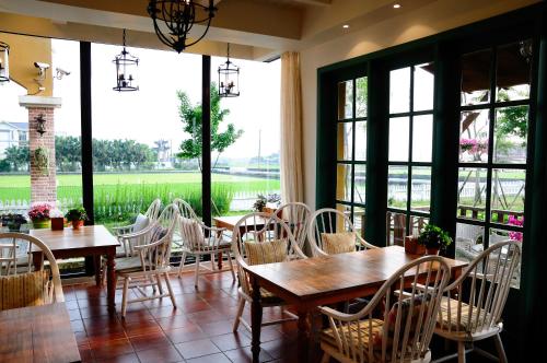 a dining room with tables and chairs and large windows at Sunday Home in Dayin