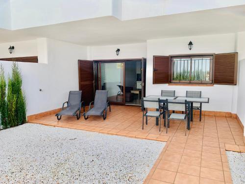 a patio with a table and chairs and a dining room at Playa and Chill in San Juan de los Terreros