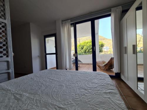 a bedroom with a bed and a view of a patio at Las Negras CENTRO. Al lado del mar. Con dos terrazas in Las Negras
