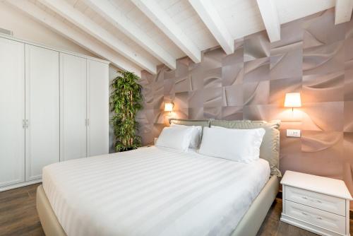 a bedroom with a large white bed and a plant at Hotel Stella Della Versilia in Marina di Massa