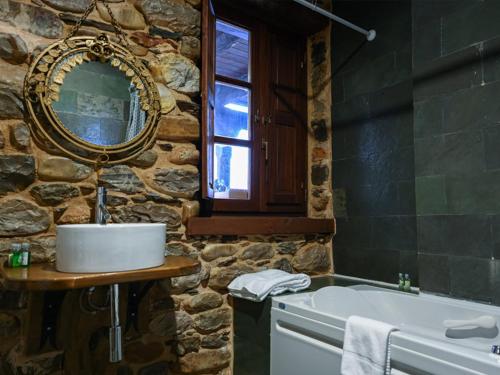 a stone bathroom with a sink and a tub at Restaurante - Hotel La Tronera in Villadepalos