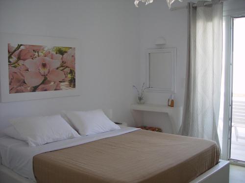a bedroom with a bed with a painting on the wall at Litsa Malli Rooms in Pollonia