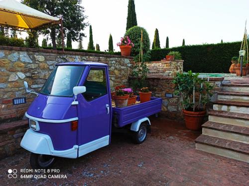 a small purple car parked next to a stone wall at Rocca degli Olivi in San Gimignano