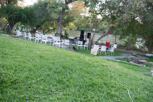 a row of white chairs sitting on a grass field at River View Villa Self Catering in Francistown