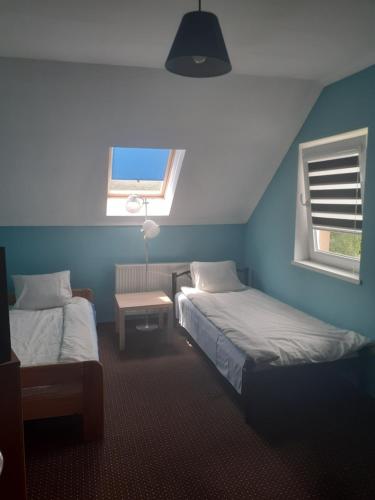 a blue room with two beds and a window at Noclegi w Kudowie in Kudowa-Zdrój