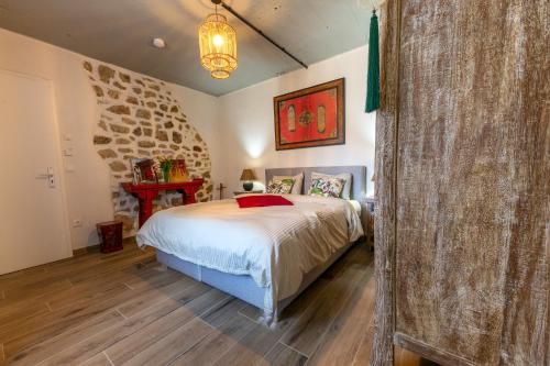 a bedroom with a bed and a stone wall at Green & Breakfast Chambre Satita in Niederpallen