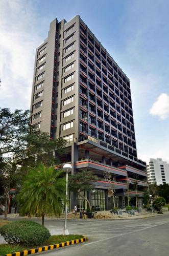 a tall building with a palm tree in front of it at Azumi Boutique Hotel in Manila