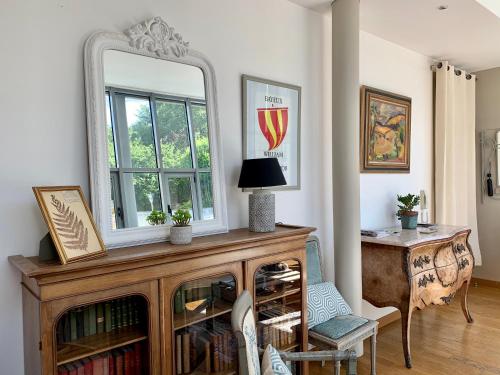 um espelho em cima de uma cómoda de madeira num quarto em Tiny house au cœur de Bayeux em Bayeux