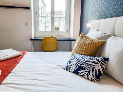 1 dormitorio con 1 cama con ventana y silla amarilla en Suite & Lake - Proche du Lac d'Annecy, en Annecy